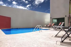 um grupo de cadeiras sentadas ao lado de uma piscina em MBM Red Sun Hotel em Monterrey