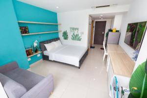 ein Schlafzimmer mit einem Bett und einem Sofa in einem Zimmer in der Unterkunft Căn hộ Orchard Garden - SG Airport Homestay in Ho-Chi-Minh-Stadt