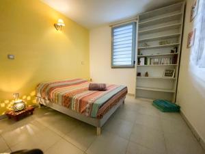 - une chambre avec un lit et une étagère dans l'établissement Le Cocon Appartement Vue Mer et Montagne, à Sainte-Marie