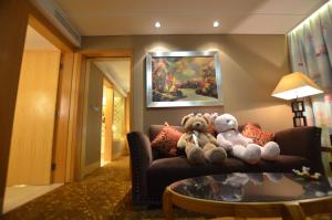 2 ausgestopfte Teddybären auf einer Couch in der Unterkunft Panyu Hotel in Guangzhou