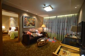 - un salon doté d'un canapé avec des animaux farcis dans l'établissement Panyu Hotel, à Canton