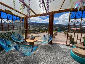 patio con sillas, mesa y vistas en Glamping Cielo Roto, en Sutamarchán