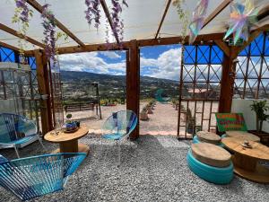 Habitación con mesas, sillas y vistas. en Glamping Cielo Roto, en Sutamarchán