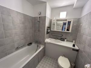 y baño con bañera, aseo y lavamanos. en Möblierte Apartment im Herkules Köln Neuehrenfeld, en Colonia