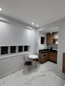 a white kitchen with a table and chairs in it at C3 STUDIO in Rio de Janeiro