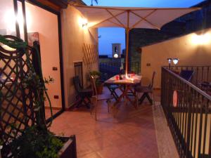 eine Terrasse mit einem Tisch und einem Sonnenschirm auf dem Balkon in der Unterkunft Appartamenti Lascaris in Lascari