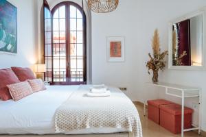 een slaapkamer met een wit bed en een raam bij Amazing Penthouse Giralda Views 8 pax, Parking Optional in Sevilla