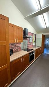 an empty kitchen with wooden cabinets and a stove at Palaz 7 - 5 bedroom house in Edmonton