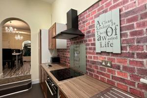 a brick wall in a kitchen with a stove top oven at Palaz 7 - 5 bedroom house in Edmonton