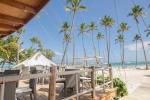 a table and chairs on a beach with palm trees at Great 3 Bed 2 Bath Condo W/Jacuzzi K102 in Punta Cana