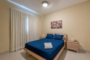 a bedroom with a blue bed and a window at Great 3 Bed 2 Bath Condo W/Jacuzzi K102 in Punta Cana +48 photos