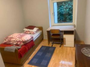 Schlafzimmer mit einem Bett, einem Schreibtisch und einem Fenster in der Unterkunft 3 Zimmer Mietwohnung nähe HBF in Essen
