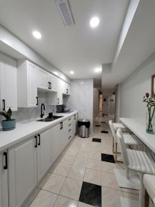 Eine Küche mit weißen Schränken und weißen Geräten in der Unterkunft RoryHouse in Toronto