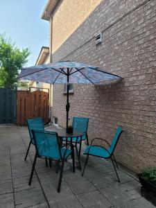 a table and chairs with an umbrella on a patio at RoryHouse in Toronto