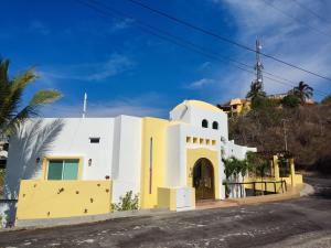 een witte en gele kerk aan de straatkant bij Casa las Palmas in Manzanillo
