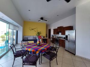 een keuken met een tafel met stoelen en een koelkast bij Casa las Palmas in Manzanillo