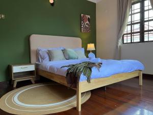 uma cama num quarto com uma parede verde em 20pax Seremban Bungalow 7000+sq ft Pet friendly em Seremban