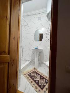 a white bathroom with a sink and a mirror at Meerim Murok in Bosteri +61 photos