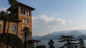 un edificio con vista sull'acqua e sulle montagne di Villa Monti a Varenna