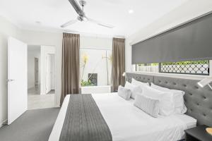 sypialnia z białym łóżkiem i dużym oknem w obiekcie Blue Lagoon Villas w mieście Trinity Beach