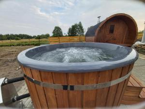uma grande banheira de madeira com água em Drewniany Zakątek z sauną i jacuzzi em Jadów