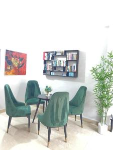four green chairs and a table in a room at Be Them homestay in Hue