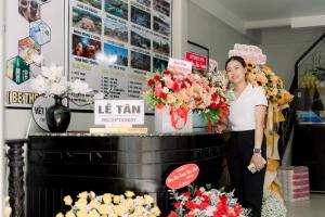 a woman standing in front of a table with flowers at Be Them homestay in Hue