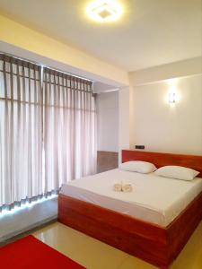 Un dormitorio con una cama con dos anillos de boda. en Sky Heaven Hotel en Kandy
