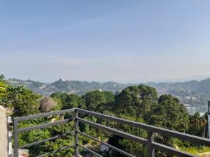a fence on top of a hill with trees at Sky Heaven Hotel in Kandy