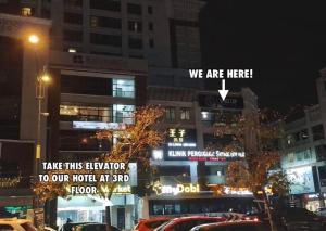 a city street with cars parked in front of buildings at Space Cap Hotel in Kota Kinabalu