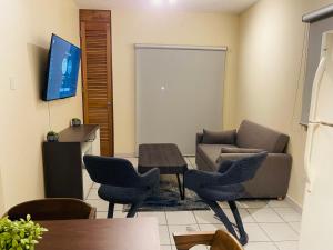 ein Wohnzimmer mit einem Sofa, Stühlen und einem Tisch in der Unterkunft 2BD 2BTH Condo in San Juan Unit 1 in San Juan