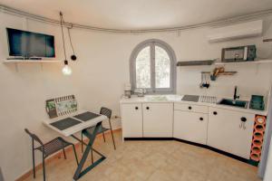 uma cozinha com armários brancos, uma mesa e uma janela em Amelie - holiday villa with private swimming pool in Benissa em Benissa