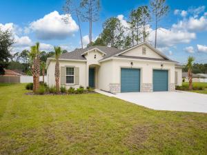 a white house with blue garage doors at Breezy Villa in Palm Coast