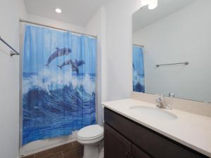 a bathroom with a sink and a shower curtain at Breezy Villa in Palm Coast +32 photos