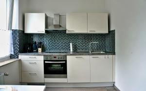 a kitchen with white cabinets and a sink at Wohnung für 1 bis 3 Personen in Solingen