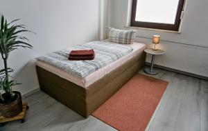 ein kleines Schlafzimmer mit einem Bett mit einem roten Handtuch darauf in der Unterkunft Wohnung für 1 bis 3 Personen in Solingen