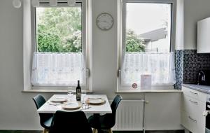 a kitchen with a table and two windows and a clock at Wohnung für 1 bis 3 Personen in Solingen +7 photos