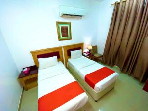 two beds in a hotel room with at Savoy Inn Hotel Apartments in Muscat