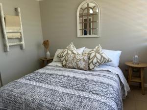 a bedroom with a bed with pillows and a mirror at Descanso y Relajo Deluxe en La Serena in La Serena