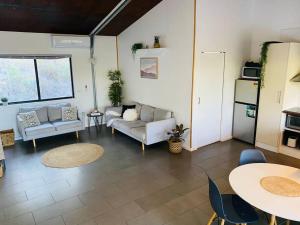 a living room with couches and a table and chairs at Austinville Hinterland Chalet in Neranwood