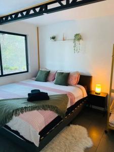 a bedroom with a large bed and a window at Austinville Hinterland Chalet in Neranwood