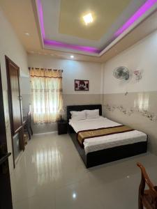 - une chambre avec un lit et un éclairage violet dans l'établissement Ngọc Nam Hotel, à La Gi