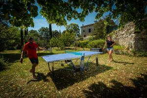 a man and a woman playing a ping pong table at Logis des Magnans -Les terrasses du Coutach - in Sauve