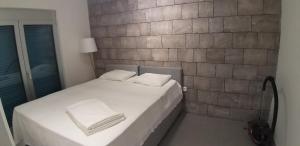 a bed in a room with a brick wall at Aksioma Kotor in Kotor +10 photos