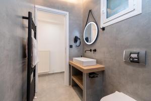 a bathroom with a sink and a mirror at Nuovo Suite in Neos Marmaras