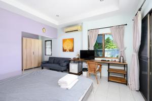 a bedroom with a bed and a desk with a computer at Sunsuko Village Panwa in Ban Bo Rae
