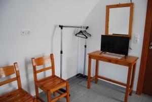Cette chambre comprend un bureau avec un ordinateur et une chaise. dans l'établissement Apollo Rooms, à Perissa