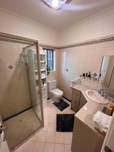 a bathroom with a shower and a sink and a toilet at West Beach House 4U in Henley Beach South