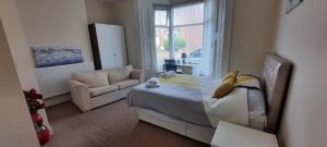 a living room with a bed and a couch at City Centre Ensuite Home - Free parking, near Uni & Hospital in Sunderland