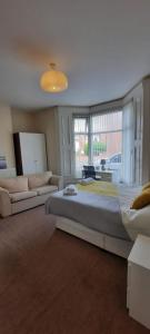 a large bedroom with a large bed and a couch at City Centre Ensuite Home - Free parking, near Uni & Hospital in Sunderland